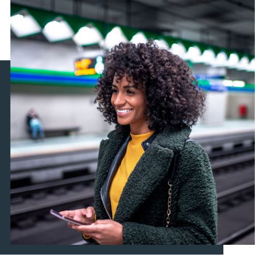Women smiling on a phone in a train station